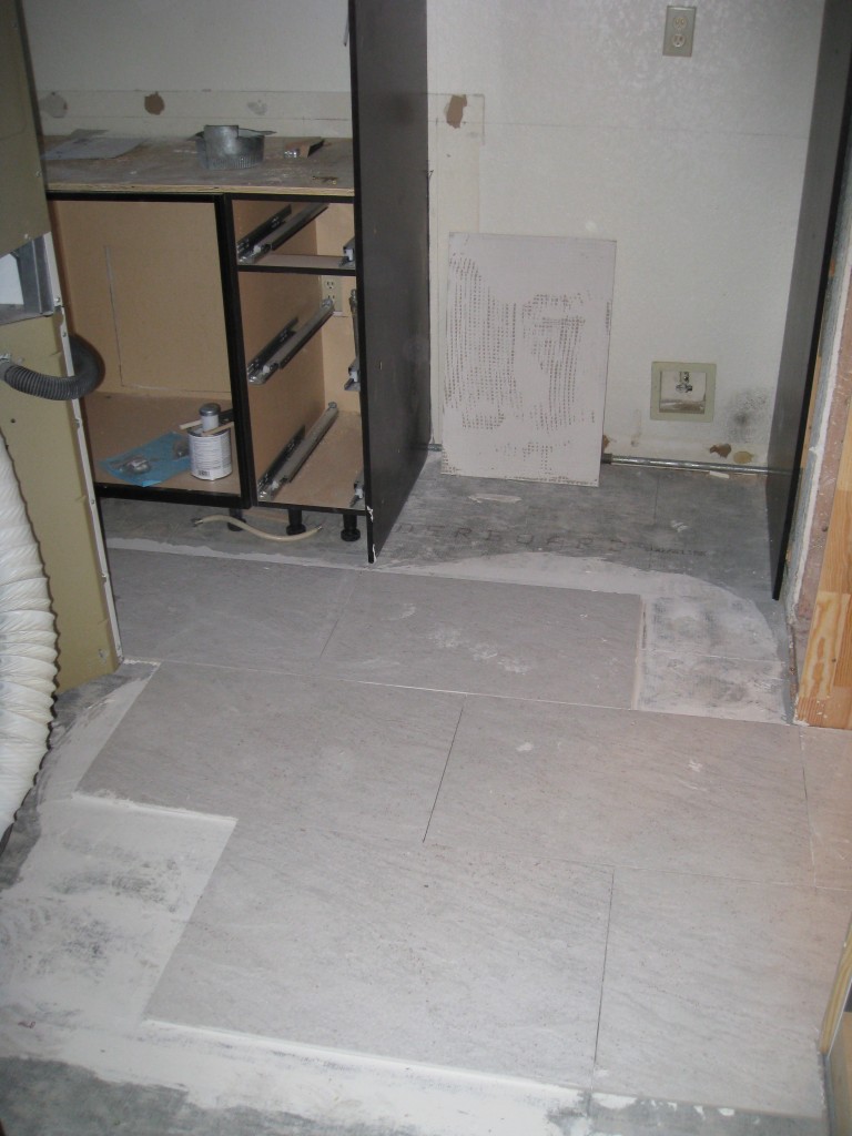 My beautiful tile, which looks like a kind of white slate, is over halfway installed.